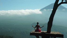 Aerial 4K Drone Footage: Serene Yoga at Lahangan Sweet, East Bali; Girl in Anjali Mudra Pose on Tree Platform, Gazing at Agung Volcano; Ideal for Wellness Blogs, Meditation, and Travel Videos