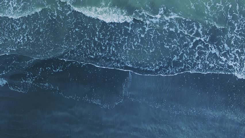 up view. The crashing waves of the sea hit the sandy beach