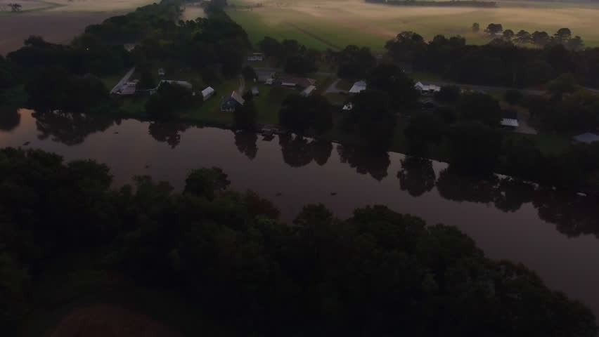 Aerial Panning Shot Of River With Landscape Against Orange Sky At Sunset - Bayou, Louisiana