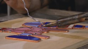 designer decorator connects pieces of ground and cut glass into a stained glass window using tin, rosin and a soldering iron - Powered by Shutterstock - Get 15% off with code: PIKWIZARD15