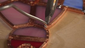designer decorator connects pieces of ground and cut glass into a stained glass window using tin, rosin and a soldering iron - Powered by Shutterstock - Get 15% off with code: PIKWIZARD15