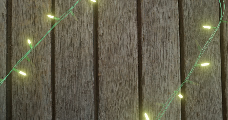 Animation of frohe weihnachten text over fairy lights on wooden background. Christmas, tradition and celebration concept digitally generated video.