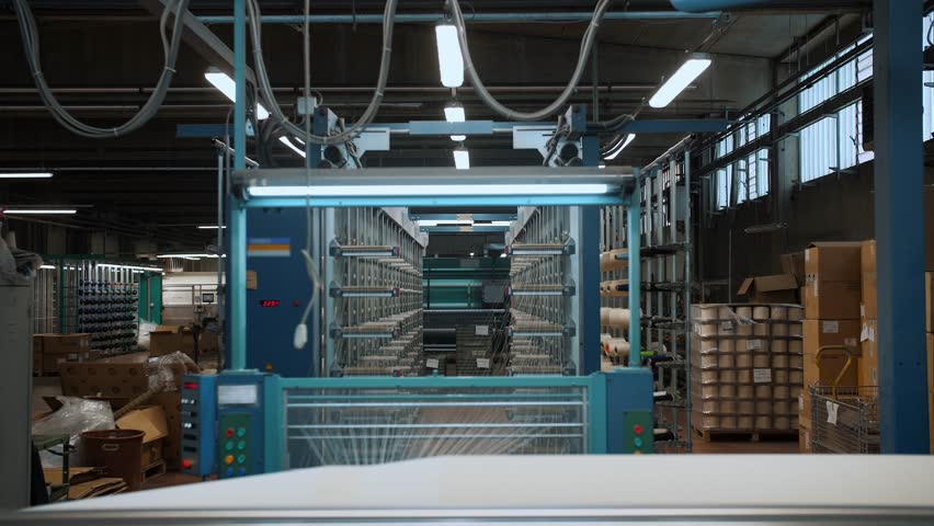 weaving factory workshop. thread coloring. Textile factory equipment winds threads onto a big spool. automated work process. fabric production factory. Weaving. 
