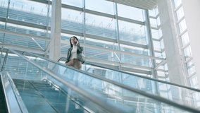 Escalator, phone call and business woman in office for commute, travel and arrival at work. Corporate, professional and female person on smartphone for career, job and journey in modern workplace - Powered by Shutterstock - Get 15% off with code: PIKWIZARD15