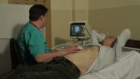 SRBIJA,KRUSEVAC, 20.05.2015. Ultrasound. Examination of abdomen with ultrasound. Review stomach. Monitor screen. Reviewing patient tummy with ultra sound. Patient lying and doctor examining him.