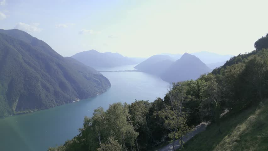 Aerial dolly with stunning view of Lake Lugano, Switzerland and Mount Brè. Incredible landscape of mountains and lake.  Drone shot over Mount Brè, Lugano. 