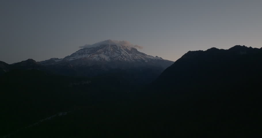 Aerial view of Mount Rainier at dawn just as the sun begins to illuminate the sky above Gifford Pinchot National Forest in Washington State.