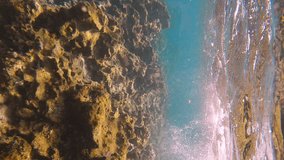Vertical video, Sea waves crashing on coastal rock reef, Rhodes island, Mediterranean sea, Greece