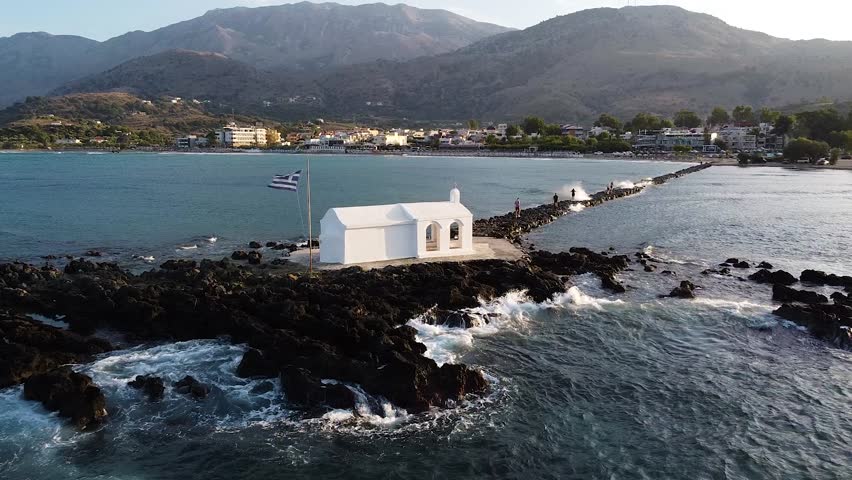 White Chapel with Greek flag in Georgiopoli, Crete, aerial view