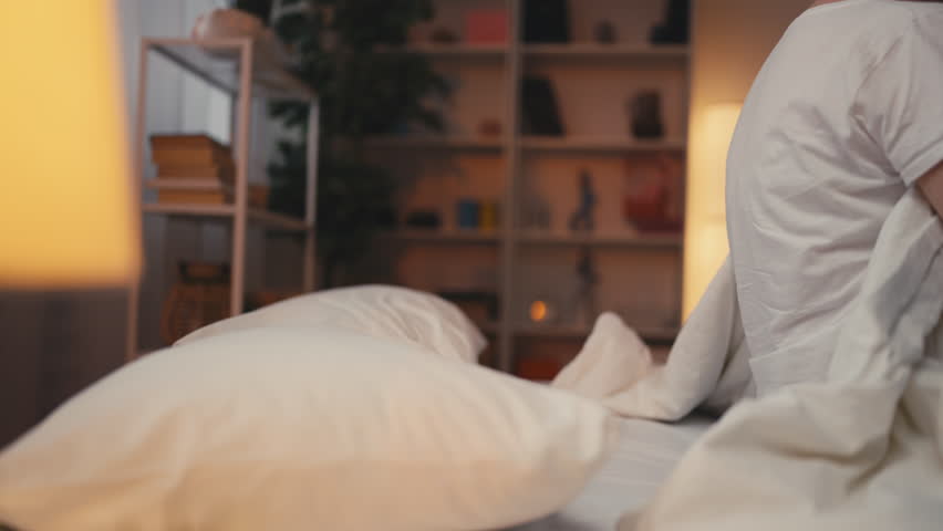 Relaxed woman falling on comfy bed at night, finally rest after a long workday Royalty-Free Stock Footage #1110705319