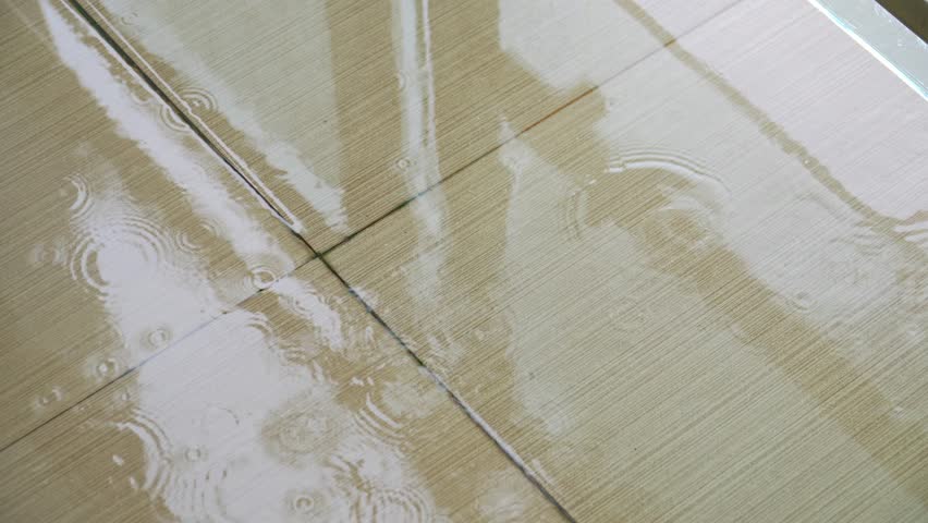 Wet ceramic floor from rain. wet ceramic floor stagnant rainwater. a tiled floor is flooded with rainwater that falls on the terrace of a building | Shutterstock HD Video #1110708191