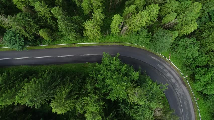 Empty road, sharp turn. Twisted mountain road through the forest aerial cinematic view. Mountains in summer and curved road through forest. Epic drone footage of highway in the wild mountain scenery.  | Shutterstock HD Video #1110710529