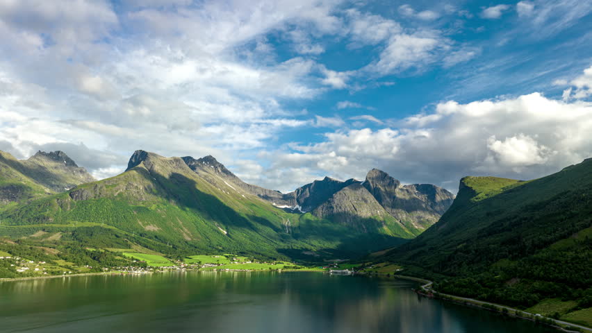 Pristine natural scenery of Norwegian fjord, Innfjorden. White clouds motion above mountain peaks.