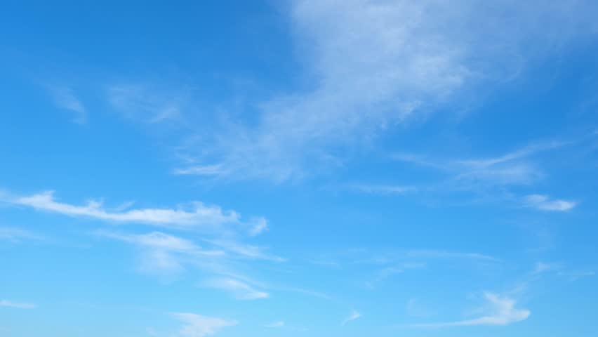 Blue sky time lapse - A timelapse of the blue sky adorned with fluffy white clouds evokes tranquility. The clouds dance gracefully, casting shadows that paint a dynamic canvas of nature's beauty. 4K.

