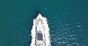 Vertical drone video on a moving yacht over turquoise water during daytime 