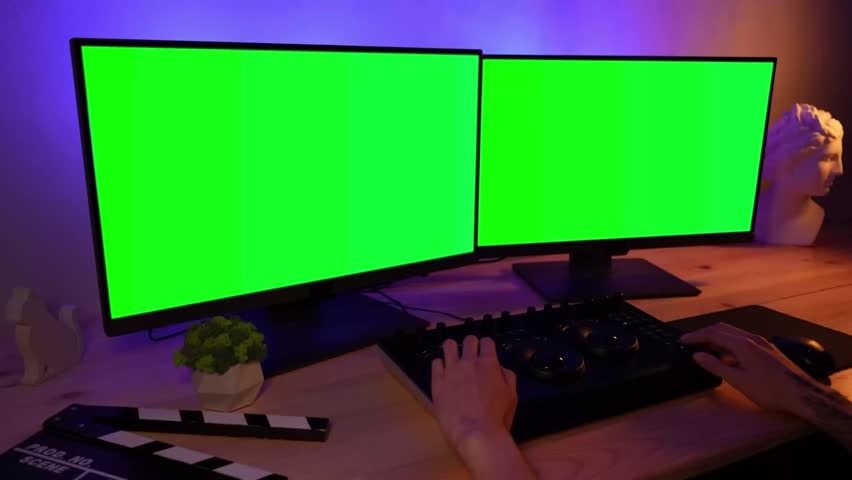 Closeup shot of monitors at the desk, male hands working on mixer and editing fencing video changing settings.