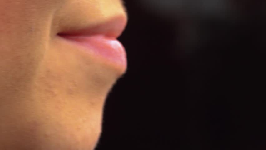 A woman smokes an electronic cigarette. The girl inhales smoke from a cigarette
