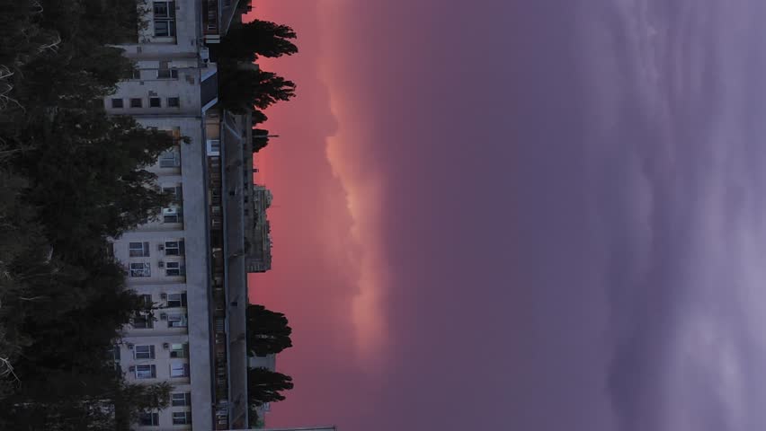 Fancy sunset over the building. Red and pink clouds over the city