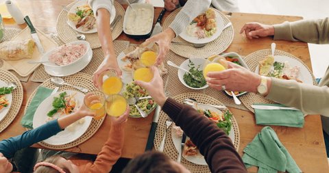 Lunch, cheers and family with juice in dining room for health, wellness and nutrition meal. Toast, celebrate and top view closeup of people with fruit beverage at a brunch or breakfast event at home. Video Stok