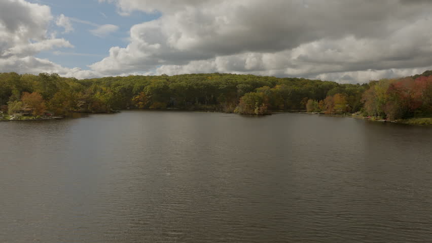 Flyover beautiful lake in the Hudson Valley area of New York state on a beautiful day in Autumn.