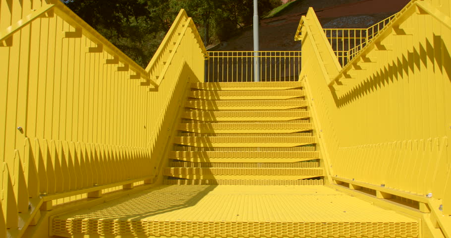 Yellow metal staircase represents an architectural feature that is not only functional but also serves as an aesthetic and visual element within the cityscape Vibrant yellow color enhancing visibility Royalty-Free Stock Footage #1110741069