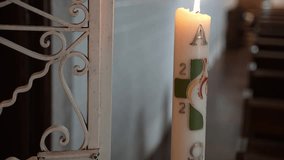 Paschal candle with symbols and burning flame inside church - closeup - Powered by Shutterstock - Get 15% off with code: PIKWIZARD15