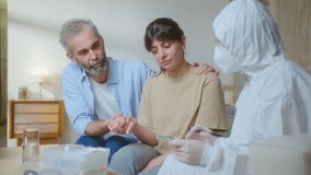 Husband supporting sick wife during medical consultation with doctor in protective coverall and mask, getting healthcare service at home during COVID-19 pandemic - Powered by Shutterstock - Get 15% off with code: PIKWIZARD15