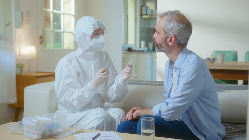 Doctor in protective coverall, mask and gloves taking nasal swab and collecting specimen in test tube, checking male patient for COVID-19 during lockdown - Powered by Shutterstock - Get 15% off with code: PIKWIZARD15