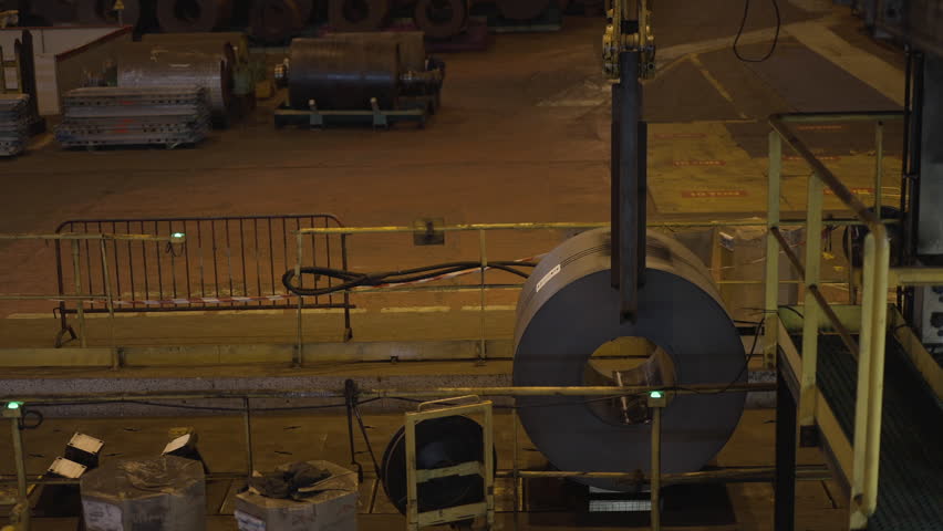 Crane At Steel Plant Lifts Large Metal Circle. Mechanized Production. Cylinder Shape.