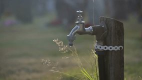 Outdoor water faucet dripping in sunset light - Powered by Shutterstock - Get 15% off with code: PIKWIZARD15