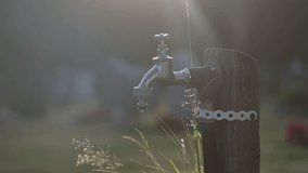 Outdoor water faucet dripping in sunset light - Powered by Shutterstock - Get 15% off with code: PIKWIZARD15