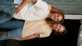 Vertical portrait video: A girl in a t-shirt and jeans hugs her curly-haired boyfriend in glasses. Rest in the country house
