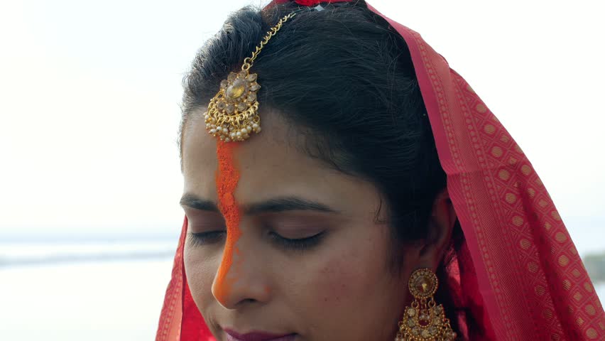 Closeup shot of an Indian woman smiling at the ghat during the auspicious Chhath Puja celebration, Bihari woman, newlywed girl . Indian woman wearing beautiful saree and jewelry during the auspicio...