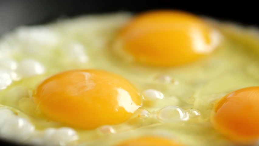 Сooking Fried Eggs For Breakfast on a Frying Pan 