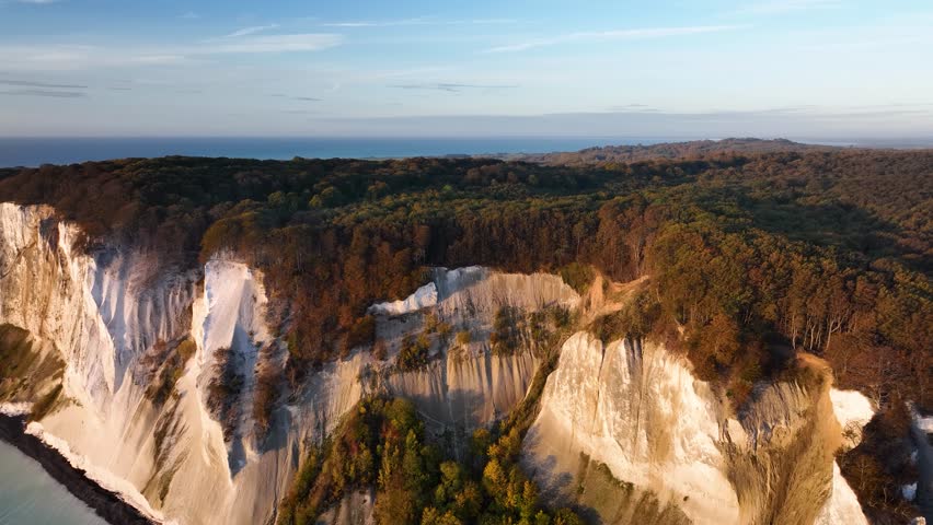 Aerial view of Denmark's Highest Cliff at Møns Klint and its landscape with dense beech forests that fringe the cliffs provide a picturesque backdrop to the stunning scenery. Dolly approach at Møns. Royalty-Free Stock Footage #1110771257