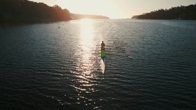 Cinematic shot of a drone on a sports canoe driven by four athletes in an ocean bay, tracking shot. Halifax, Canada. Aerial view of a crew of athletes rowing a boat at sunrise. - Powered by Shutterstock - Get 15% off with code: PIKWIZARD15