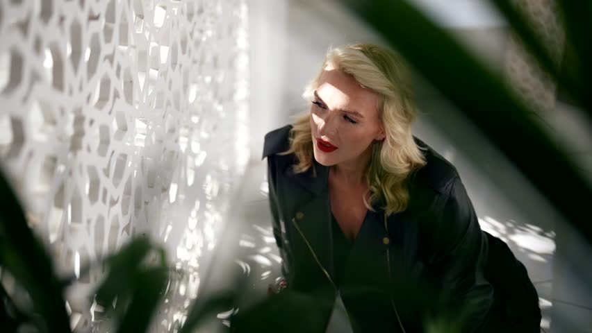female beauty and sensuality, sexy middle-aged blonde woman looking at window with decorative fence