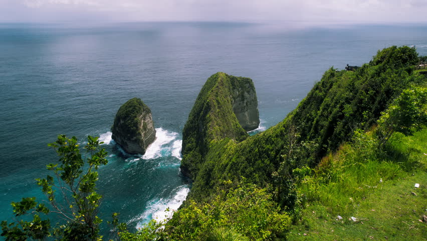 Kelingking beach with tall overgrown rocky cliff and turquoise ocean Nusa Penida Bali. Aerial view of best travel destination in Indonesia.