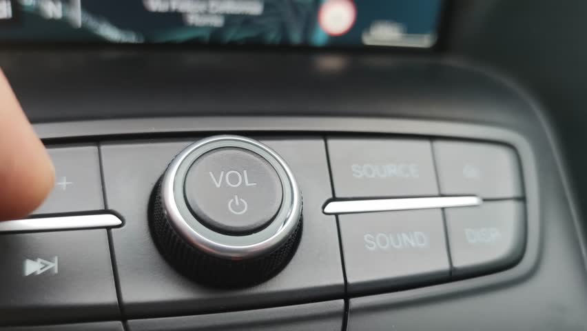 Macro close-up, turning down the volume of the car radio