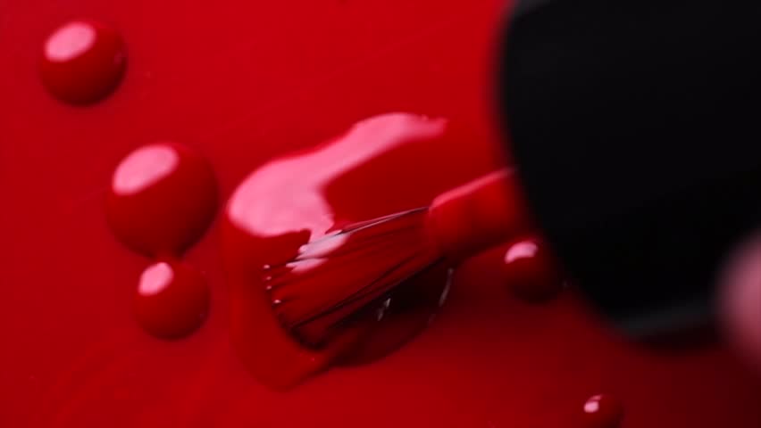 Red nail polish drops, manicure concept. Spilled uv gel, enamel, varnish with brush on red color background, splash. Beauty salon, nail care product. Nail art. Top view, fashion backdrop. Slow motion. Royalty-Free Stock Footage #1110782333