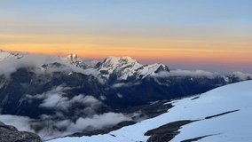Beautiful Sunset time view time lapse video from Mera peak High Camp at cca 5750m with running foggy clouds with small Kangchenjunga third-highest mountain in the world 8586 m on horizon.