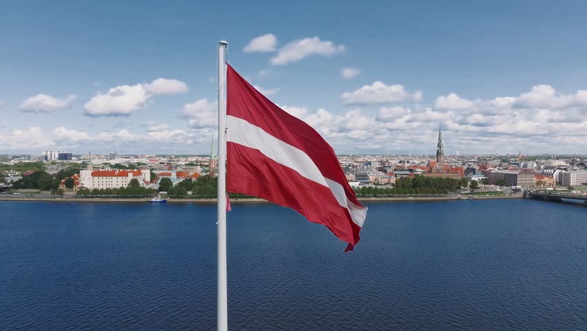 Close-up view of the Flag of Republic of Latvia. Huge Latvian flag waving in the wind against the sun Royalty-Free Stock Footage #1110783785