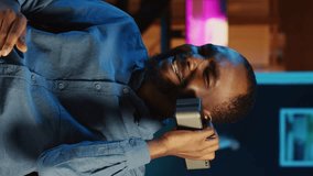 Vertical video African american internet star doing technology review of Bluetooth portable speaker for online platforms channel. BIPOC influencer presenting music playing device to his viewership - Powered by Shutterstock - Get 15% off with code: PIKWIZARD15