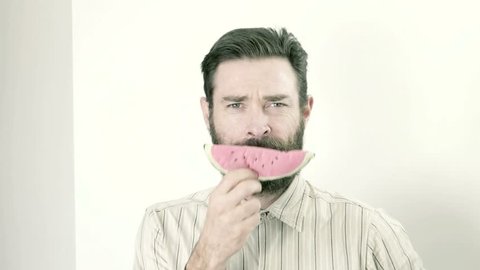 man with fake watermelon toy smiling 