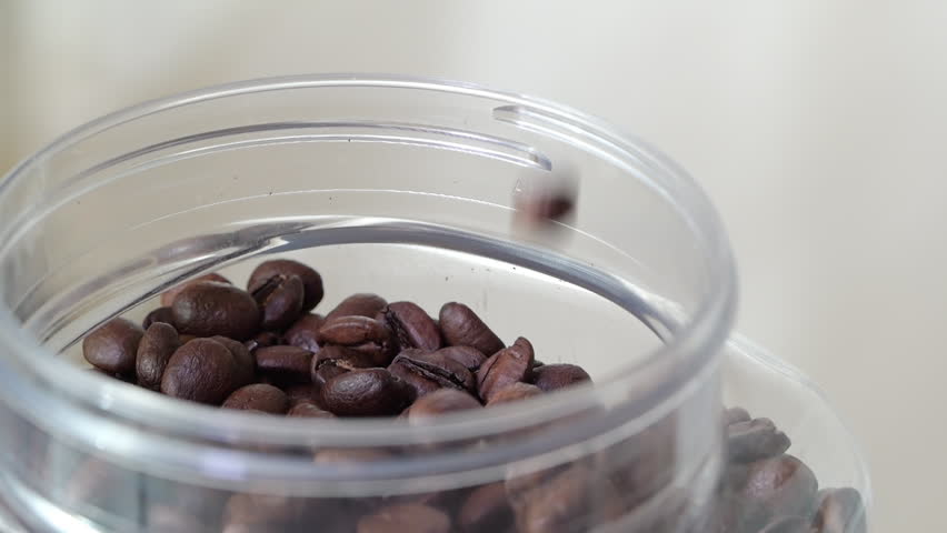 Close-up of freshly roasted coffee beans. Slow motion of falling coffee beans into storage container | Shutterstock HD Video #1110793879