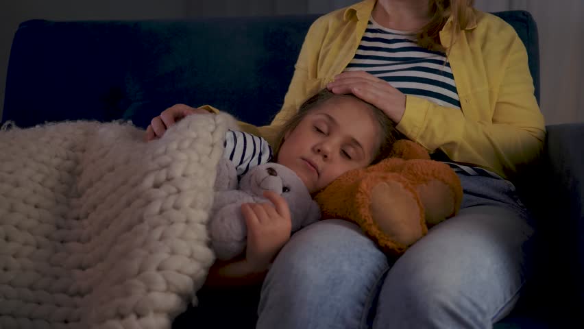 Happy family concept. mother with child and teddy bear at home in bedroom. woman puts baby to sleep.child lies on his mother's lap under blanket and hugs a teddy bear. baby sleeping with a teddy bear Royalty-Free Stock Footage #1110796007