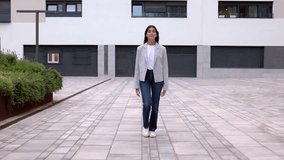 Front view of young confident businesswoman walking from business office building. Full body portrait of successful female entrepreneur commuting at city urban street.  - Powered by Shutterstock - Get 15% off with code: PIKWIZARD15