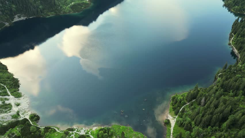 Dramatic aerial view of blue mountain lake in the Beautiful mountain region. High Tatras in Poland or Slovakia. Morskie oko. Dramatic snow covered mountain peaks backdrop. Five valley lake