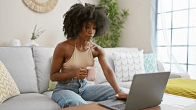 African american woman having video call drinking coffee at home