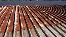 Rusty roof. Corrugated steel panels – oxidized galvanized metal sheets on the outer wall of a production workshop or warehouse. Rusty pattern of an aged iron roof - Powered by Shutterstock - Get 15% off with code: PIKWIZARD15